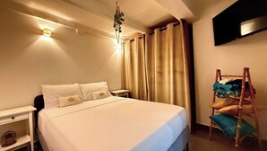 A neatly arranged hotel room with a bed, bedside table, and a TV mounted on the wall.