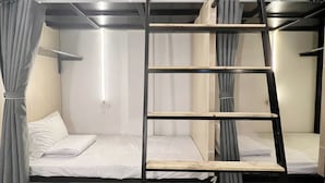 A bunk bed room with a ladder, a small table, and a curtain. - Heritage Corner Hostel (Hanoi)