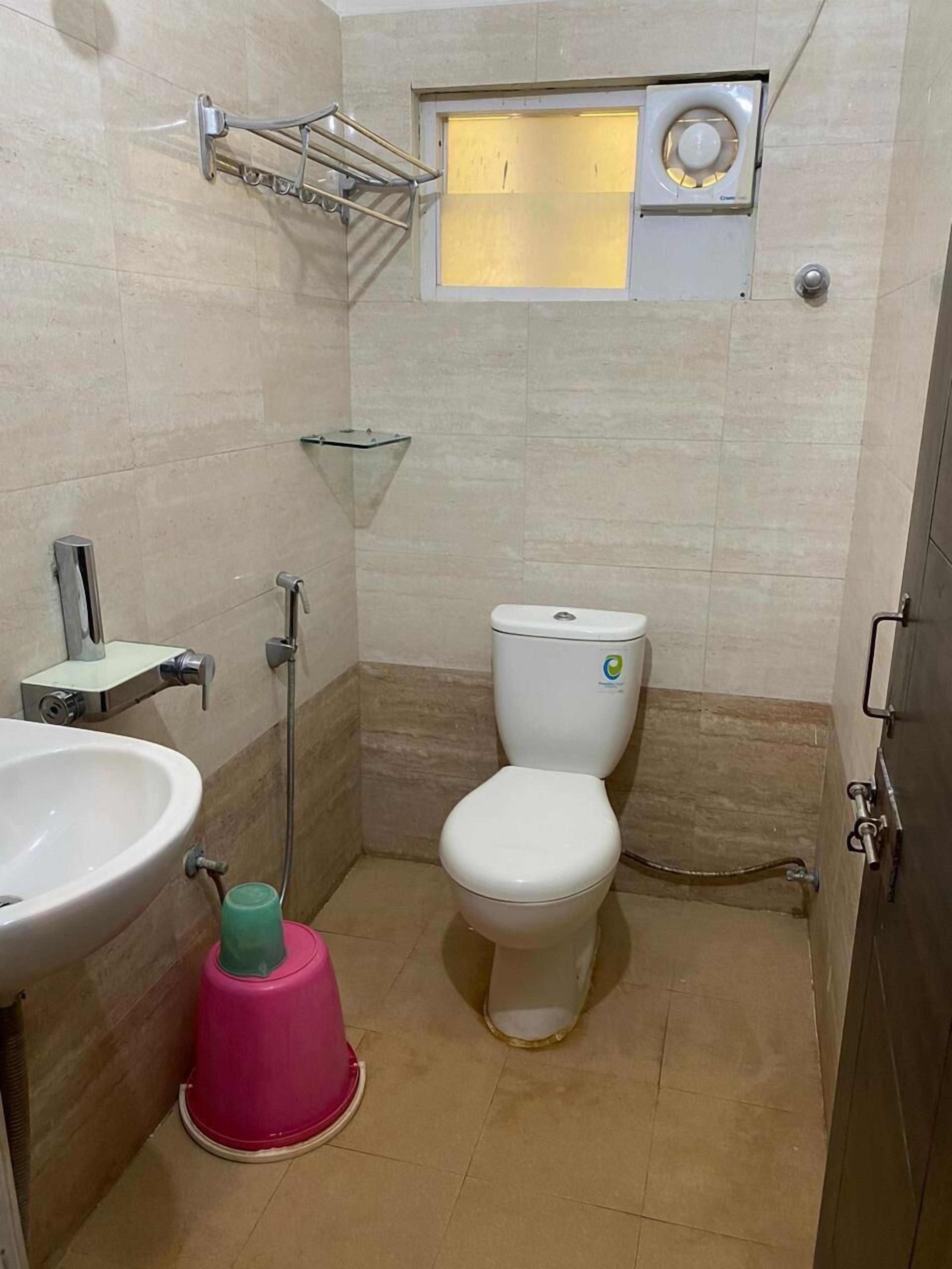 Un baño pequeño con inodoro blanco, lavamanos y ducha.