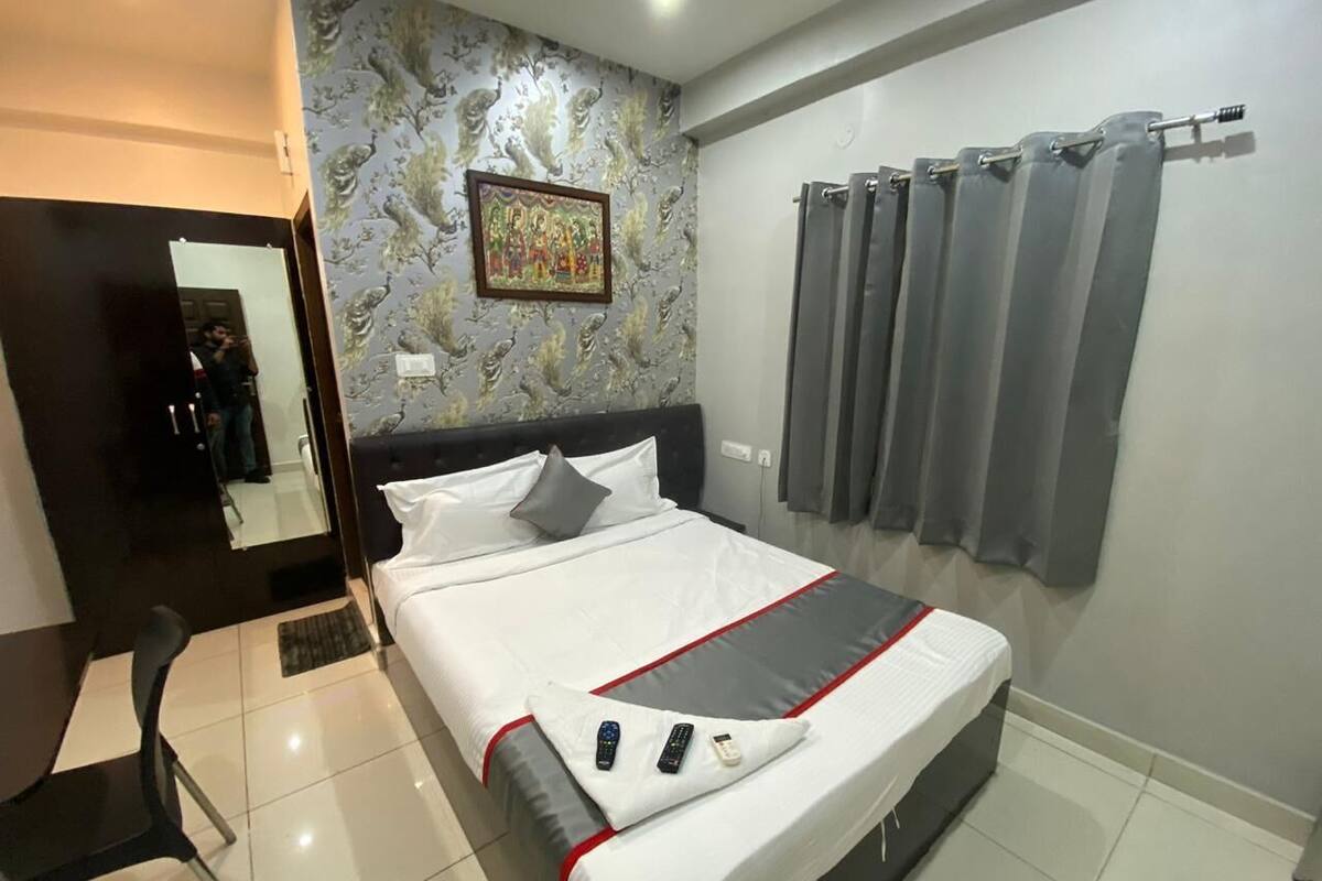 Hotelkamer met een bed, bureau, stoel, badkamer en douche.