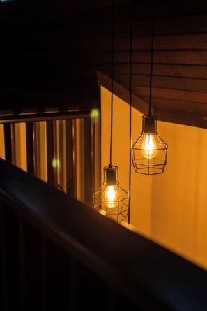 Two hanging pendant lights with exposed bulbs in a dimly lit room.