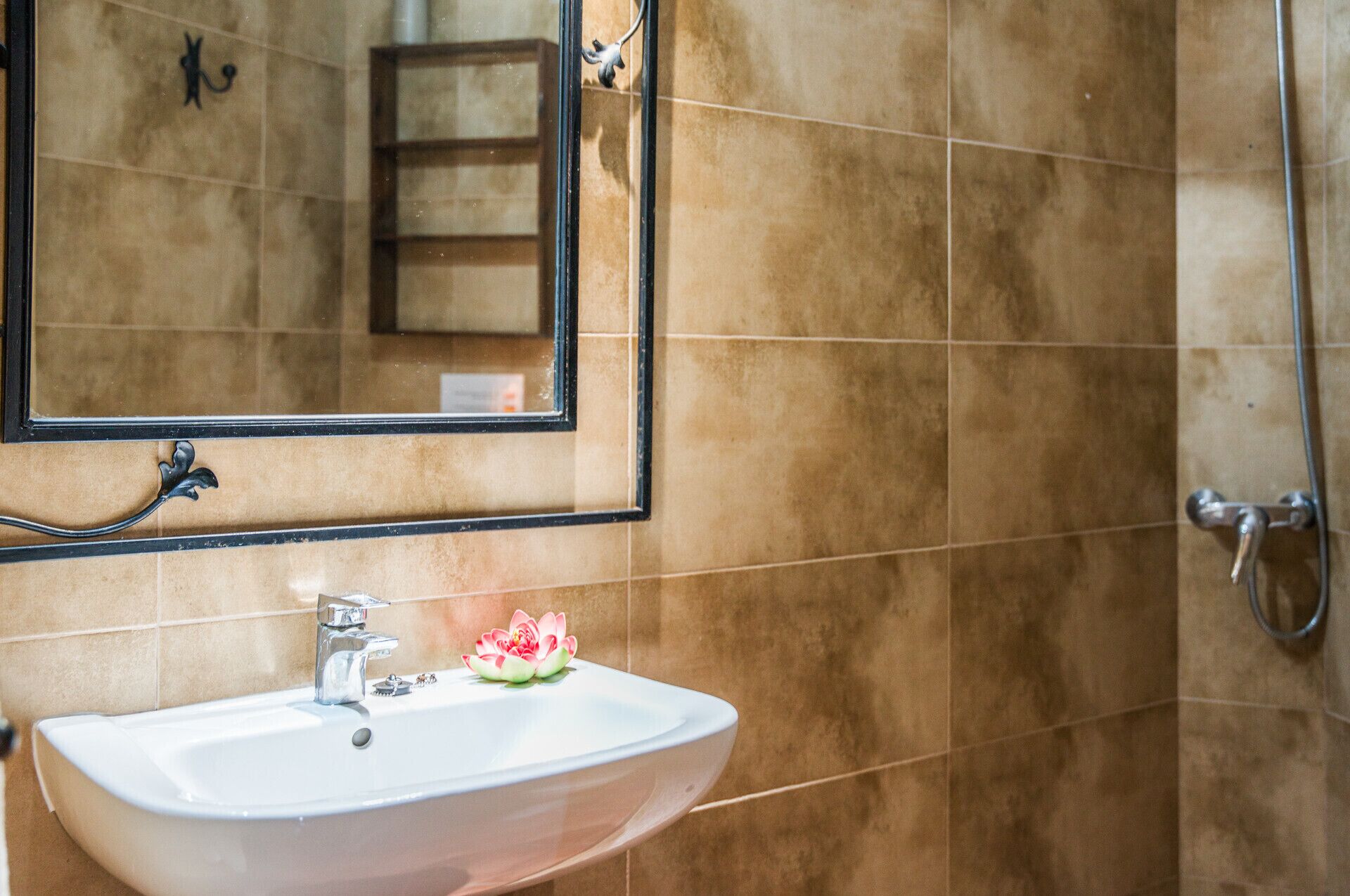 A bathroom with a white sink, a mirror, and a shower area.