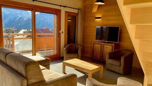 A cozy living room with a sofa, chairs, a coffee table, and a TV. - 250m from ski slopes, 6th floor, balcony, tv, 99m², Les 2 Alpes (Les Deux Alpes)