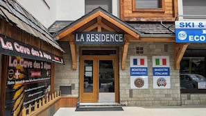 Rakennuksessa on kyltti, jossa lukee ”LA RESIDENCE”, sekä kaksi pienempää kylttiä, joissa lukee ”MONITEURS” ja ”MAESTRI ITALIANI”.