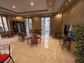 Un salon moderne avec un téléviseur, un coin salon et une grande fenêtre.
