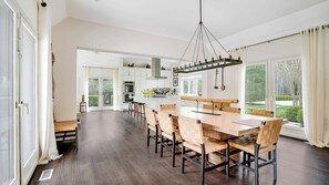 A spacious kitchen with a central island, large windows, and a view of the outdoors. - Spacious Wainscott Escape with Private Pool, Spa, and Luxurious... (Wainscott)