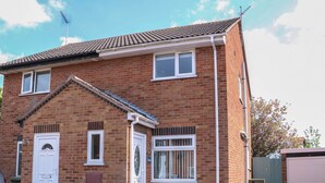 A two-story brick house with a front door, a garage, and a small porch area. - Sweetacres (Great Yarmouth)