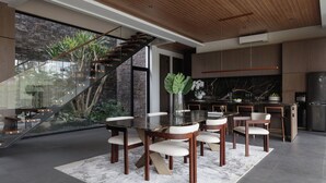 Una cocina moderna con encimera de mármol, horno empotrado y refrigerador de acero inoxidable.