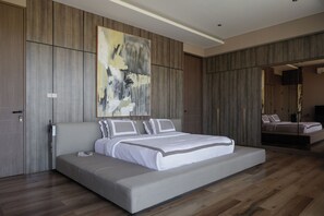Un dormitorio moderno con una cama grande, paneles de madera y un cuadro abstracto de gran tamaño.