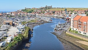 A coastal town with a marina, historic buildings, and a prominent church on a hill. - 2 bedroom accommodation in Whitby (Whitby)