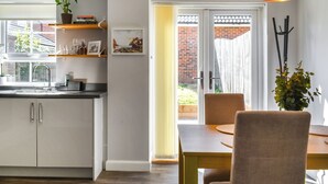 A modern kitchen with white cabinets, a wooden countertop, and a potted plant on the shelf. - 2 bedroom accommodation in Whitby (Whitby)