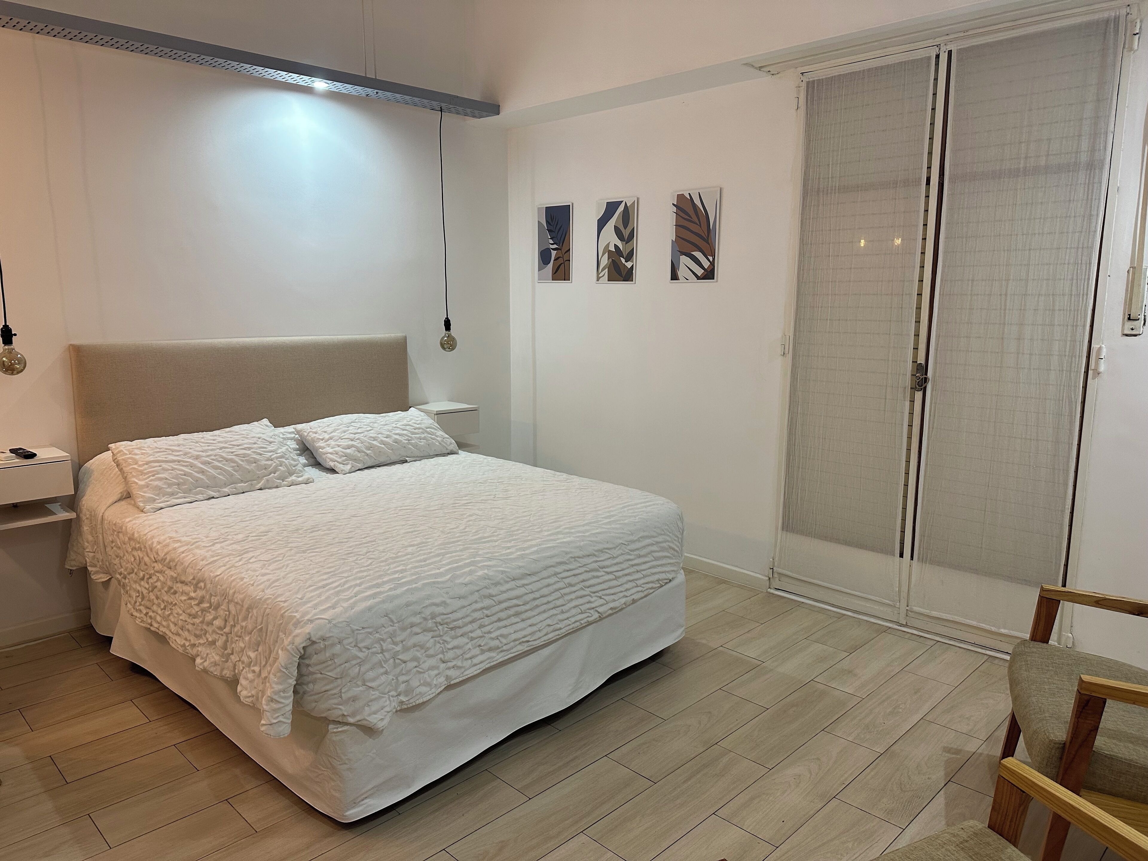Una camera da letto con un letto, un comodino, una sedia e un armadio.