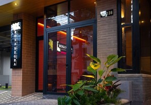 Een hotelingang met een glazen deur, een bord waarop 