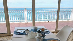 A table set for breakfast with a view of the sea.
