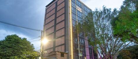A multi-story building with a modern glass facade and a brick base.