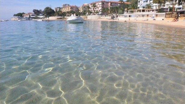A clear beach with a boat in the water and buildings in the background. - Ajaccio center ville magnifique appartement neuf vue mer 5p plage wifi parking (Ajaccio)