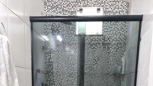 A bathroom with a glass shower enclosure, a white toilet, and a black sink. - Apartment in Belém cop30/2025 (Coqueiro Ananindeua)