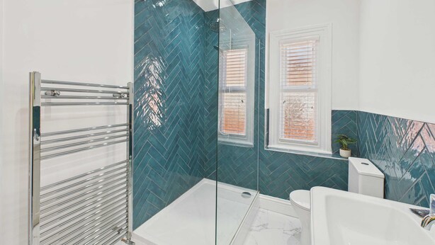 Une salle de bain moderne avec une douche à l’italienne en verre, une baignoire blanche et une porte en verre.