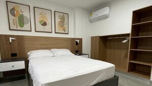 Une chambre à coucher moderne avec un grand lit, une armoire et une table de chevet.
