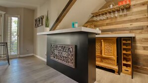 A modern kitchen with a wooden accent wall, a built-in wine rack, and a decorative panel. - Charming Oasis Apartment (El Paso)