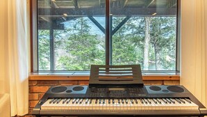 Et tastatur med en holder foran et vindue med udsigt til træer.