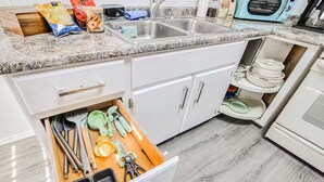A kitchen with a drawer organizer containing utensils, a microwave, and a toaster. - Sunset Sanctuary - El Paso (El Paso)