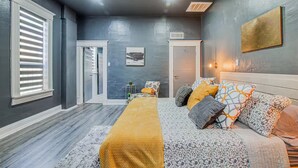 A bedroom with a bed, a sofa, a door, and a window with blinds. - Sunset Sanctuary - El Paso (El Paso)