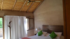 A bedroom with a bed, a wooden headboard, a window with curtains, and a ceiling fan. - Vientonorte (Tilcara)