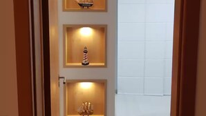 A hallway with three illuminated display cases containing ship models. - 1 bedroom apartment (1 bedroom) Le Bon Vivant (Praia Grande Arraial do Cabo)