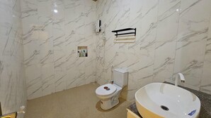 A bathroom with a toilet, a sink, and a shower area. - Kuri Himandhoo Inn (Himandhoo)