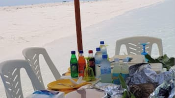 En la playa, arena blanca, sillas reclinables de playa, sombrillas