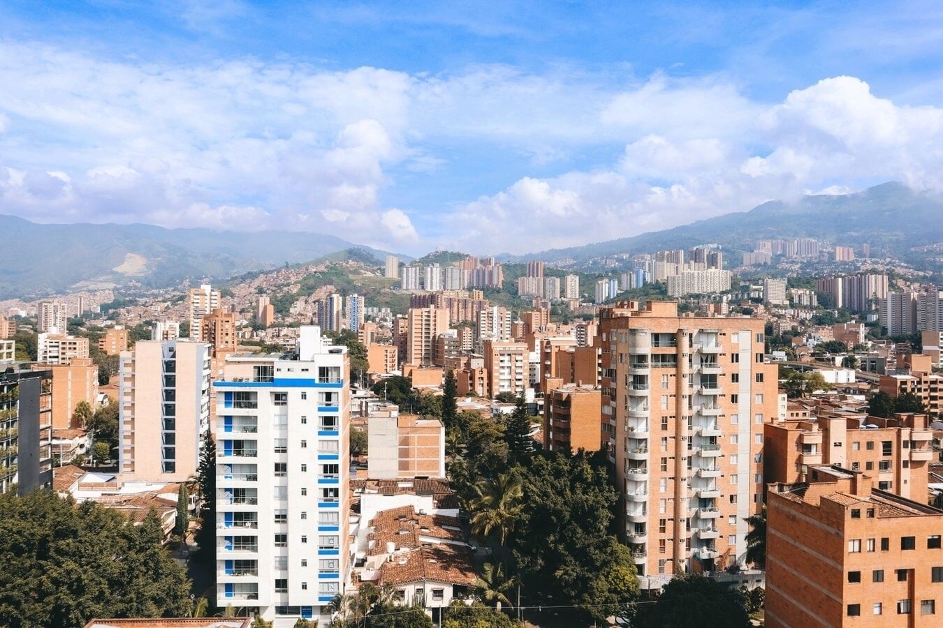A cityscape with high-rise buildings, some with balconies, and a mix of residential and commercial structures.