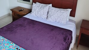 A bedroom with a bed, a nightstand, a mirror, and a small wooden table. - Baja Escape ;Work, Leisure or Explore — Your Choice! (Loreto)