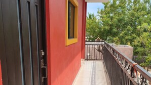 A balcony with a red wall, a yellow window frame, and a metal railing. - Baja Escape ;Work, Leisure or Explore — Your Choice! (Loreto)