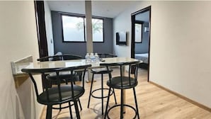 A modern kitchen with a central island, black bar stools, and a large window. - 2-Bedroom Apt in Cinta Costera (Panamá)