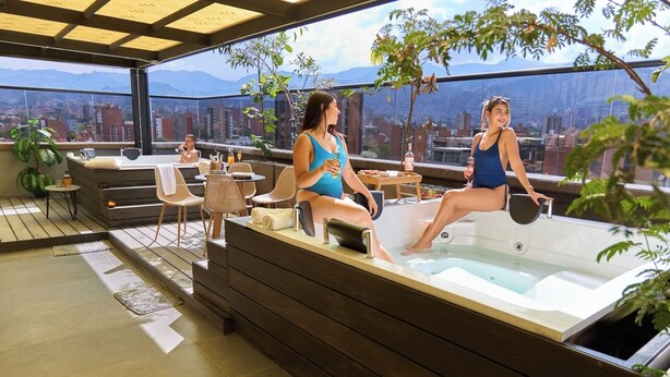 A rooftop terrace with a hot tub, seating area, and city views. - Rosa Negra Suite w/ Jacuzzi Near Stadium (Medellín)