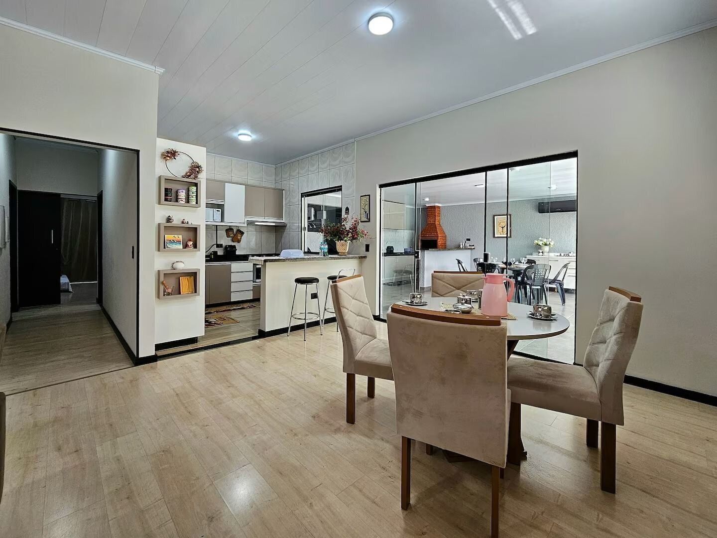 Una cocina moderna con una isla central, comedor con sillas y vista al salón comedor.