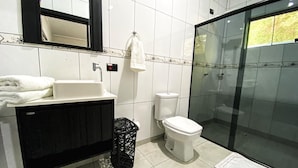 Un baño con bañera, inodoro y cabina de ducha de vidrio.
