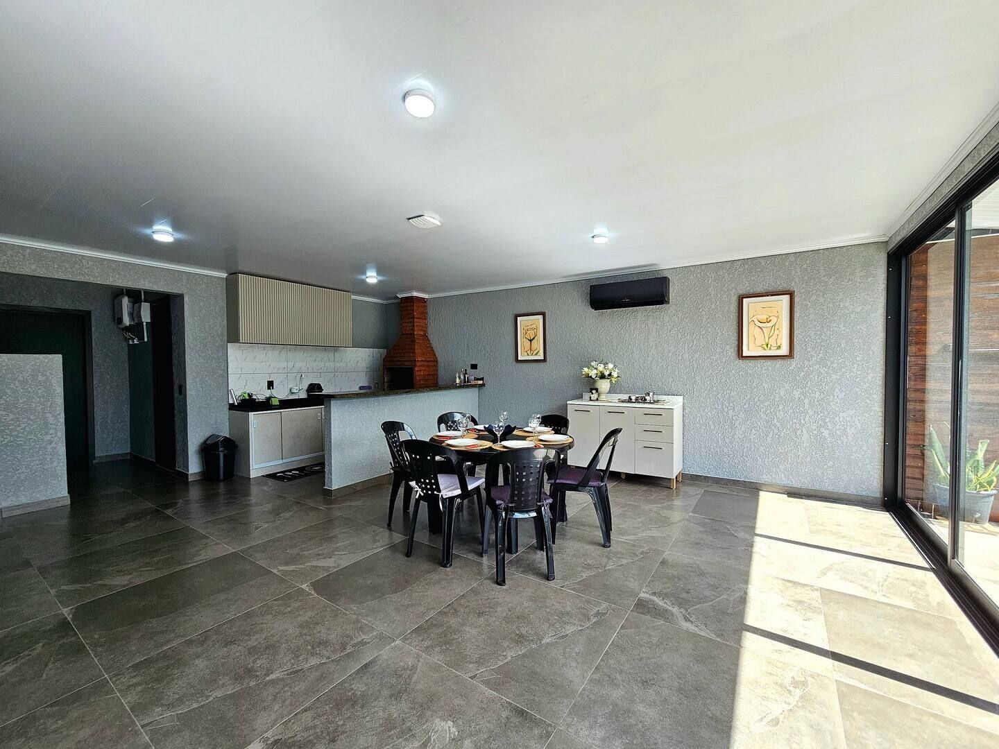 Una cocina moderna con horno empotrado, un área de comedor con una mesa redonda y sillas, y un ventanal con vistas.