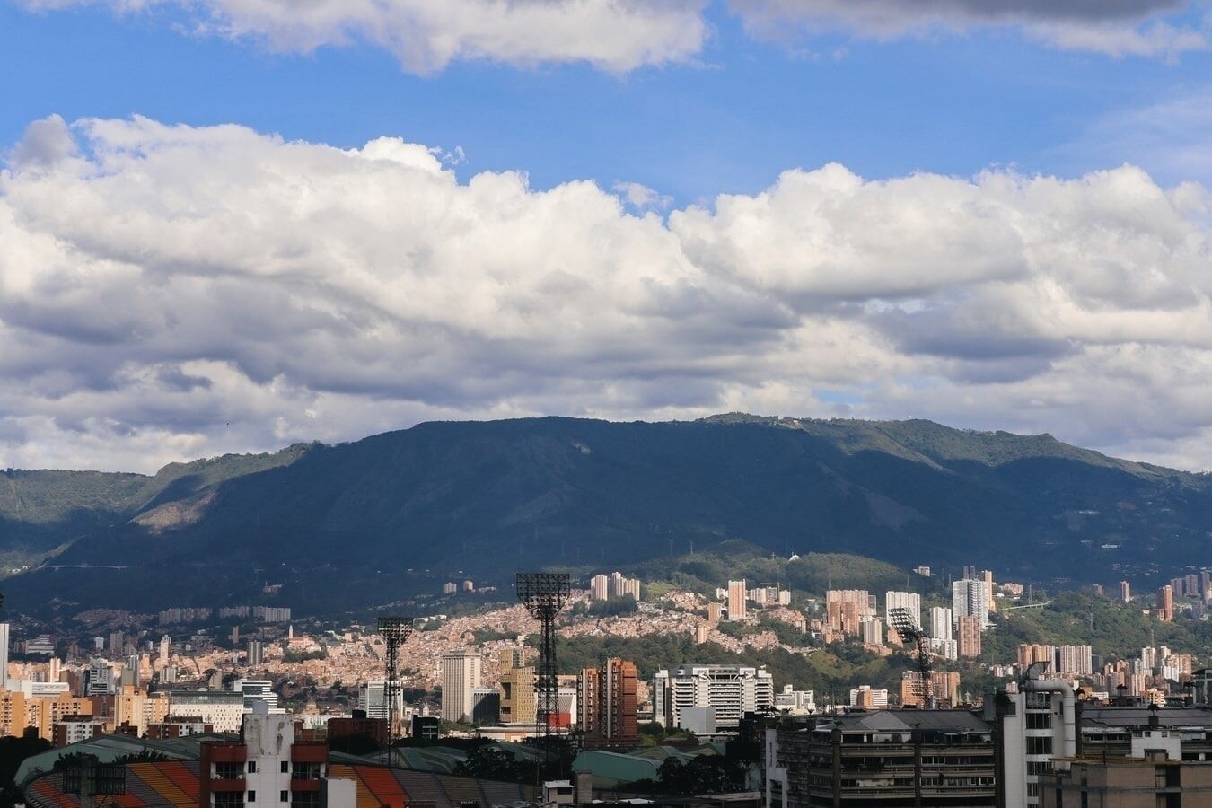 A cityscape with a mountain range in the background, featuring a variety of buildings and infrastructure.