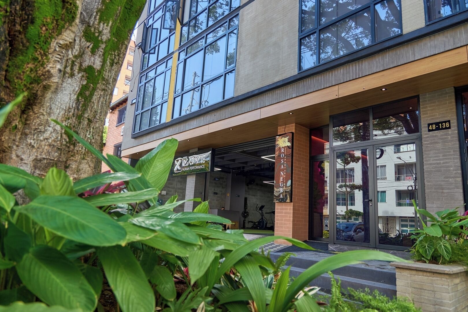 A modern building with large windows and a sign for 'Human Performance'.