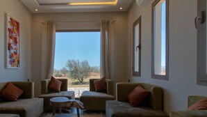 Amplia sala de estar con asientos cómodos, ventanas grandes y vistas al exterior.