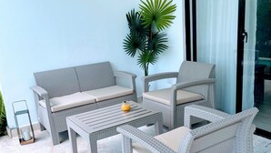 A patio area with wicker furniture, including a sofa, two armchairs, and a coffee table. - Family-Friendly White Sands 2BR - Private Pool, Fast Wi-Fi, Near Beach (Punta Cana)