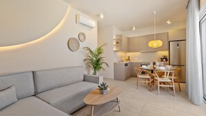 Un salon moderne avec un canapé gris, une table basse en bois et un coin repas comprenant une table et des chaises en bois.