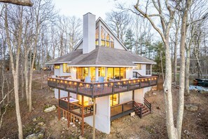 A cabin with a deck, multiple windows, and a chimney. - Mountain Views, Hot Tub, Impeccable Design (Wintergreen Resort)