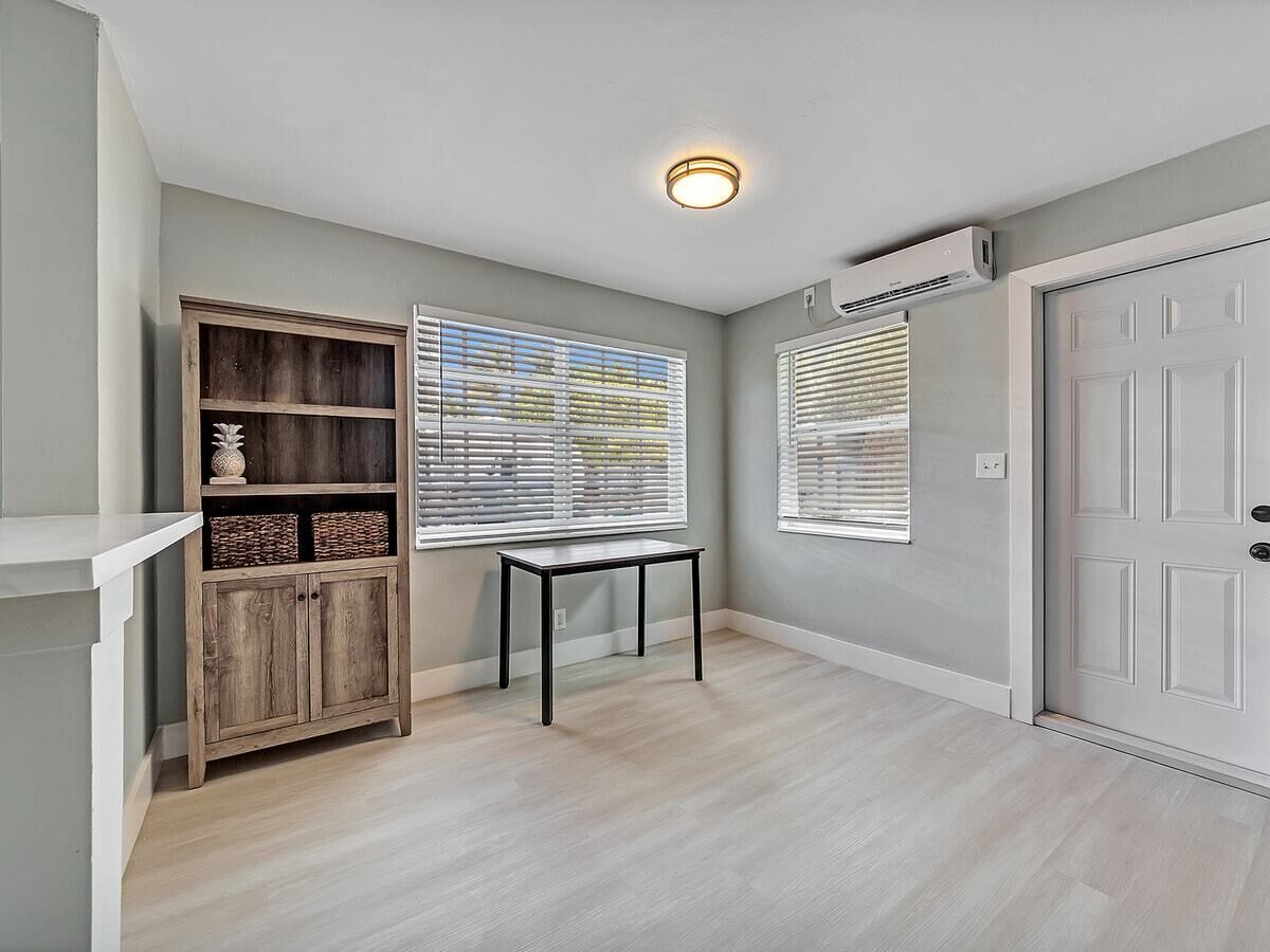 Un couloir avec une armoire en bois, une petite table et une porte.