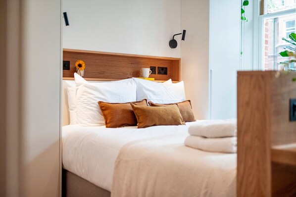 1 habitación, escritorio, tabla de planchar con plancha y ropa de cama