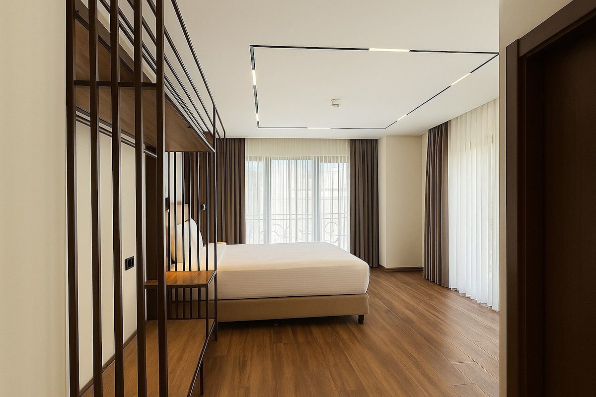 Een moderne slaapkamer met een bed, houten vloer en een groot raam met gordijnen.
