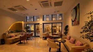 A hotel lobby with a sofa, chairs, a coffee table, and a plant. - Mandala Karaköy Hotel (Istanbul)