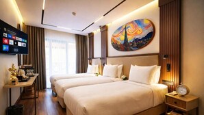 A hotel room with two beds, a TV, a painting, and a desk with a coffee machine. - Mandala Karaköy Hotel (Istanbul)